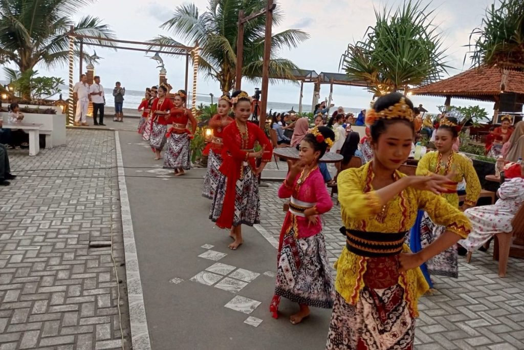 Penampilan Ritual Senja Ngukus Layung di Pantai Pangandaran dengan puluhan penari saat matahari terbenam.